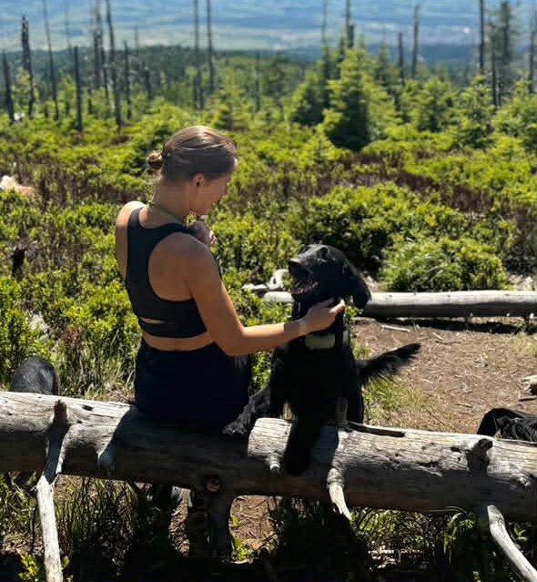Pupil 3, kobieta w bląd włosach w okularach i czerwonej bluze z czarnym psem